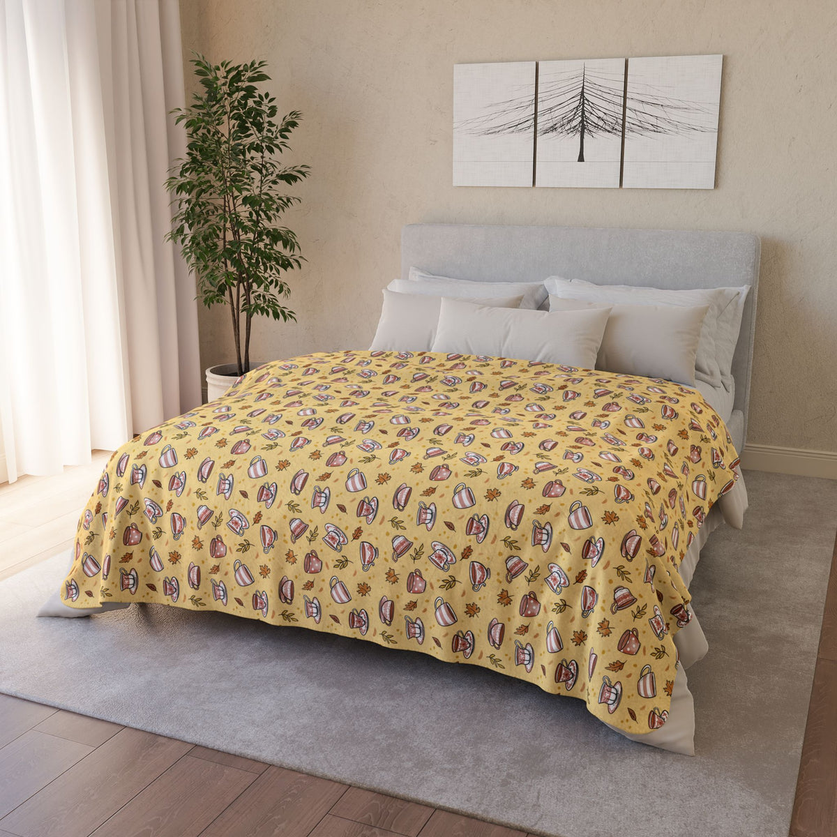 Hand drawn autumn teacups design on a pale yellow fleece blanket draped over a bed
