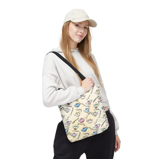 Model holds tote bag with colorful teapot and tea types pattern on white background - size small