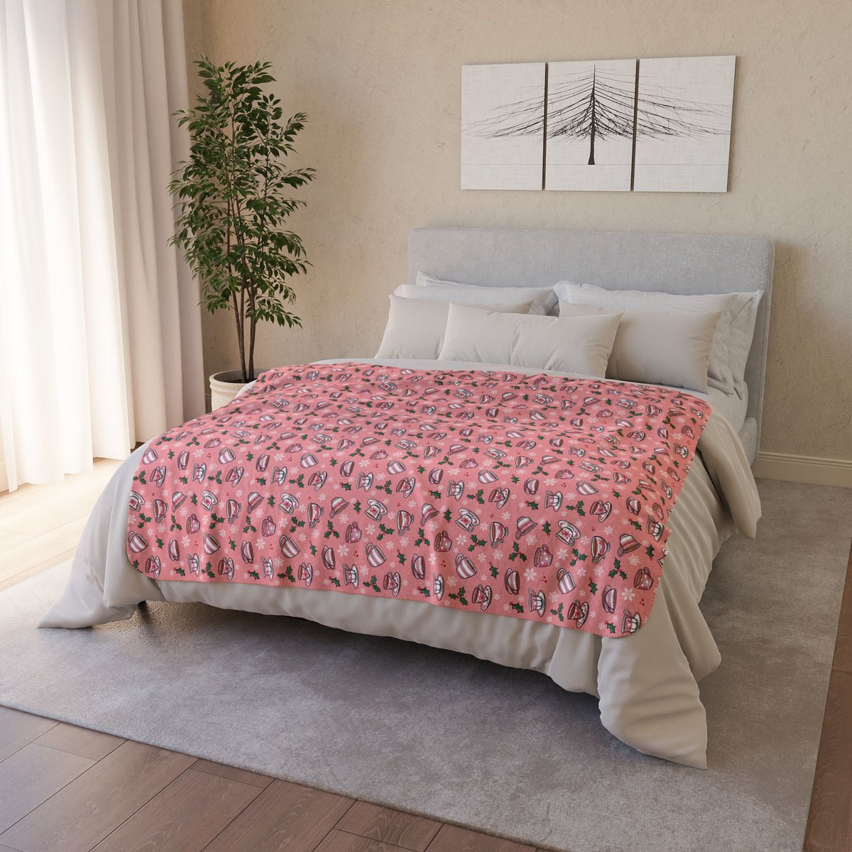 Hand drawn teacups with holly and snowflakes on a soft pink fleece blanket draped on a bed