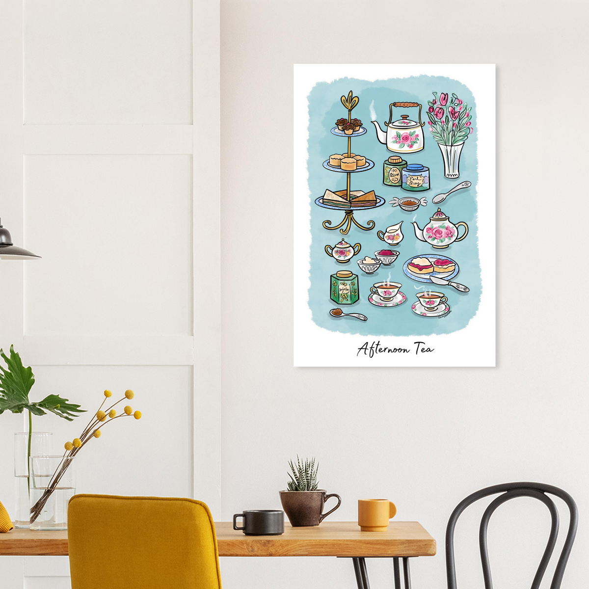 Watercolor-style art print titled 'Afternoon Tea' hanging on a white wall in a styled dining room. The print features a light blue watercolor background with illustrated tea-time items including teapots, cups, cakes, sandwiches, flowers, and tea bags.