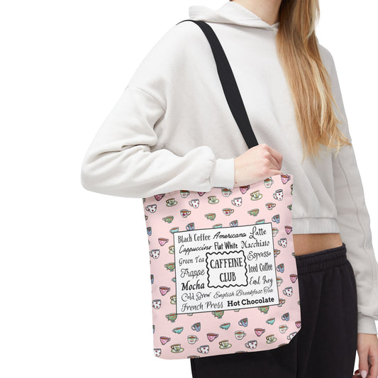 Woman holds 13"x13" pink tote bag with hand drawn cups and mugs and a central white label listing various coffee and tea types. Ideal for coffee or tea lover.