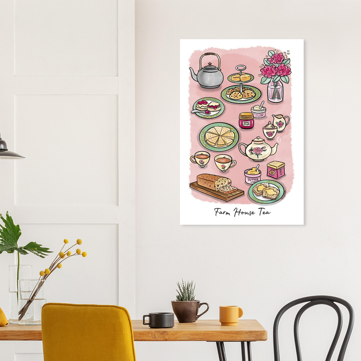 Art print featuring a whimsical tea party illustration labeled 'Farm House Tea' is displayed on a white wall in a styled dining room setting with a wooden table, chairs, and mugs.