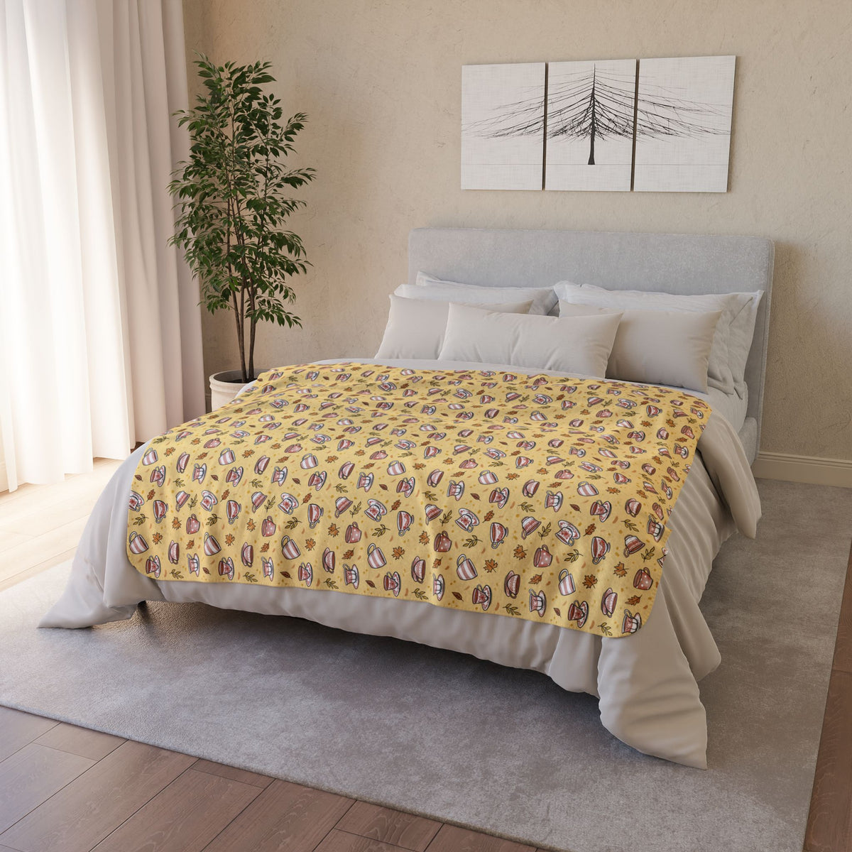 Hand drawn autumn teacups design on a pale yellow fleece blanket draped on a bed